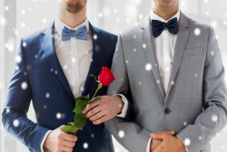 CLoseup of two young and cleancut men in suits with bowties as though at their wedding