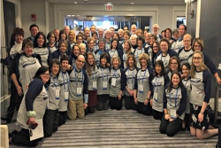 Large group of smiling URJ staffers and lay leaders in matching URJ tee shirts posing together at URJ spring training