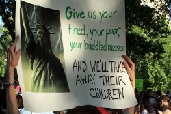 Sign with an angry looking Statue of Liberty that reads GIVE UP YOUR TIRED YOUR POOR YOUR HUDDLES MASSES AND WELL TAKE AWAY THEIR CHILDREN