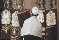 bar mitzvah boy in tallit returning the scroll to the ark