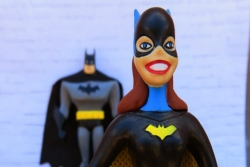Action figure of Batwoman standing near the camera with Batman in the background