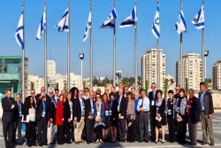 URJ board mission participants in front of Israeli flags on flag polls