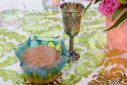 A bowl of charoset, a kiddush cup, and fresh flowers on the Passover seder table