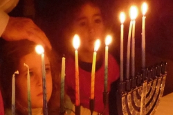 Young children watching the candles in a hanukkiyah (Hanukkah menorah)
