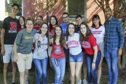 Group of smiling college students wearing their university tee shirts and sweatshirts