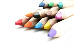 Pile of sharpened colored pencils against a white background 