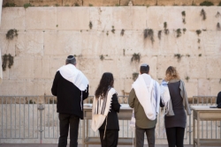 Two men and two women praying at an egalitarian section of the Kotel (Western Wall) in Jerusalem