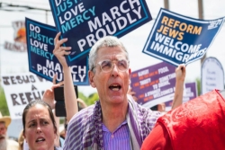 Rabbi Rick Jacobs stands in front of immigration justice signs at the recent event in El Paso Texas