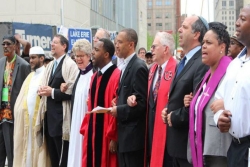 Clergy from diferent faiths standing together on an urban street