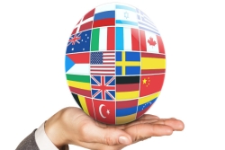 Globe covered with flags of many countries resting in the palm of someone's hand