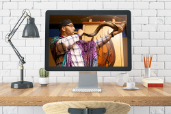 man blowing shofar on a computer screen