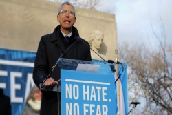 Rabbi Rick Jacobs speaking at a podium before a rally with a sign that reads NO HATE NO FEAR