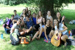 Group of teen campers outside in front of a tree