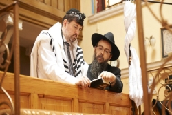 Two men in synagogue balcony, one in tallit and phylacteries