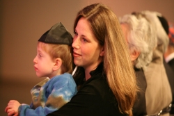 woman holding small child wearing a yarmulke in her lap during worship services