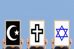 Three people, each holding a different sign in front of their face: one depicting Islam (crescent and star), one Christianity (cross), and one Judaism (Star of David)