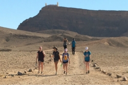 Six teens walking in an open expanse of the Negev Desert