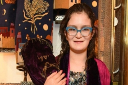 Bat mitzvah girl holding Torah scroll