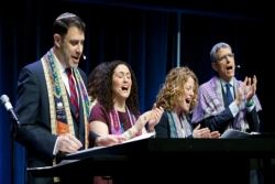 Four clergy singing from a bimah