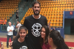 Israeli NBA star Omri Casspi poses with young female fans in a gym