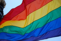 Rainbow Pride flag against a blue sky 
