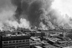 Black and white photo of the Little Africa section of Tulsa in flames during the 1921 race riot