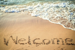 welcome written in sand on the beach