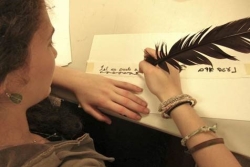 A young woman writing with a quill